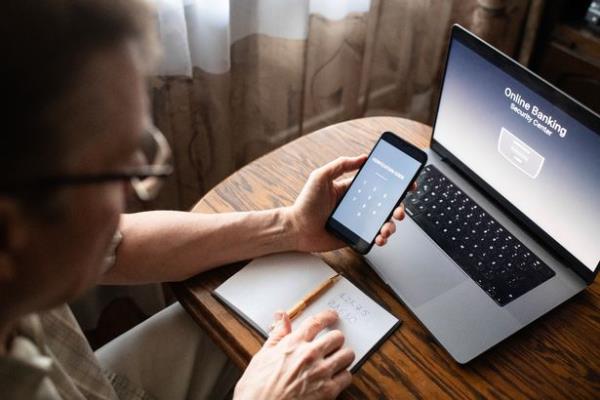 Man with phone at his laptop